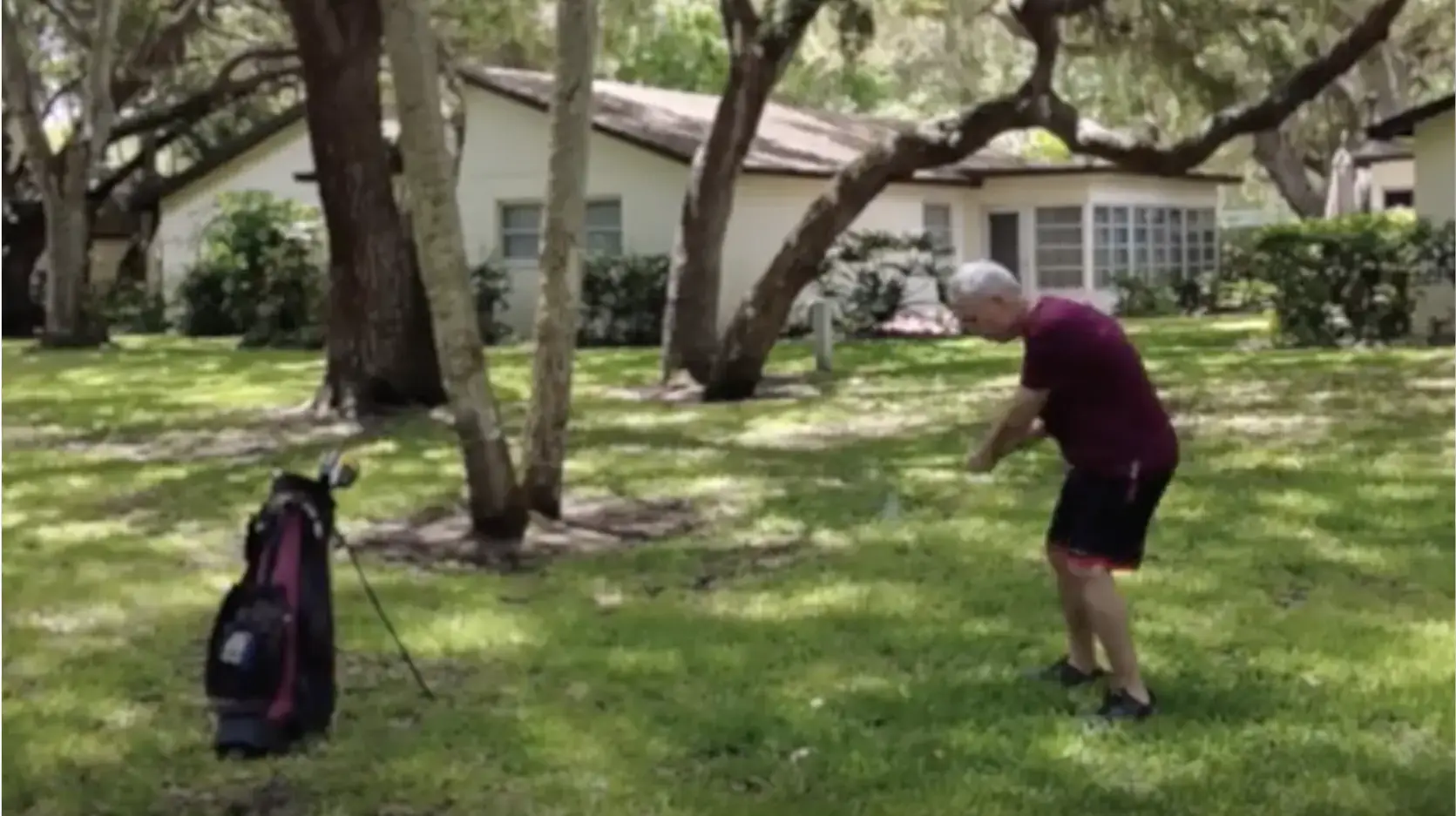 A man with a golf club stands in his front lawn, readying his swing. Text on the bottom right reads "John's Story"