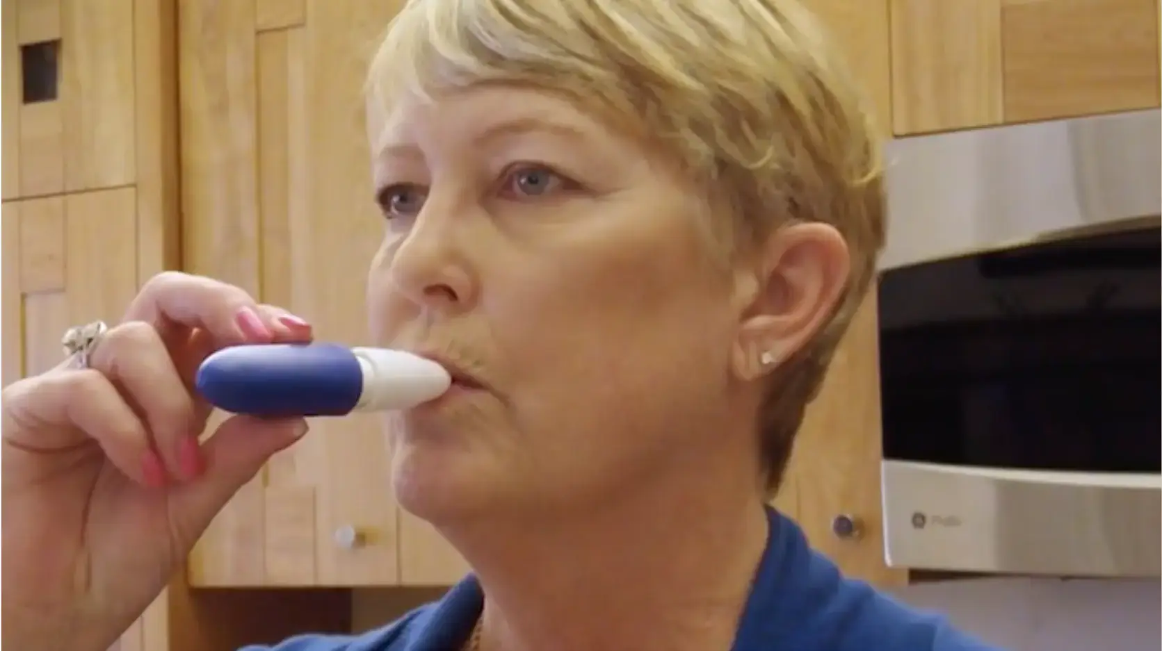 A woman with short blond hair holds the INBRIJA inhaler to her mouth. Text on the bottom right reads "Stephanie's Story"
